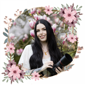 Frau hält Kamera in der Hand und lächelt sympatisch und freundlich. Sie ist umgeben von Magnolien und das Bild ist umrandet von Blumen, ein kreatives Portrait aufgenommen in Wuppertal