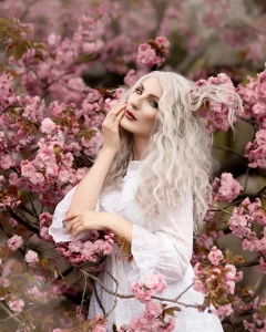Portrait einer jungen Frau mit weissen Haaren in Kirschblueten